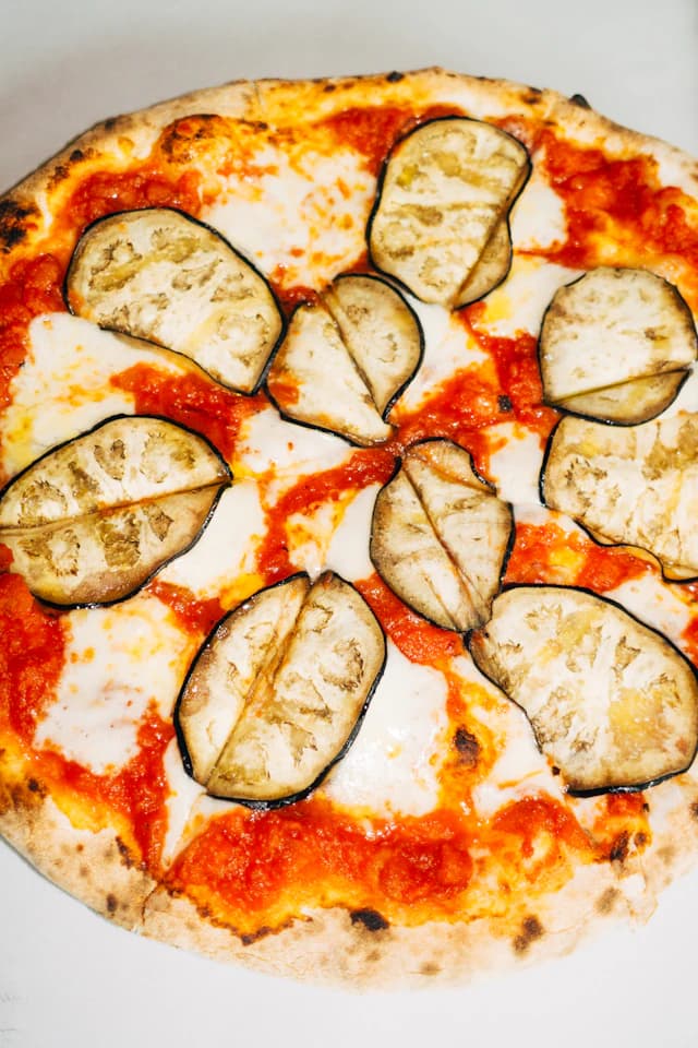Cheese pizza topped with slices of roasted aubergine — illustrative stock photograph