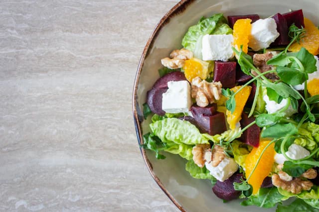 Salad with beetroot, orange segments, greens and nuts — illustrative stock photograph