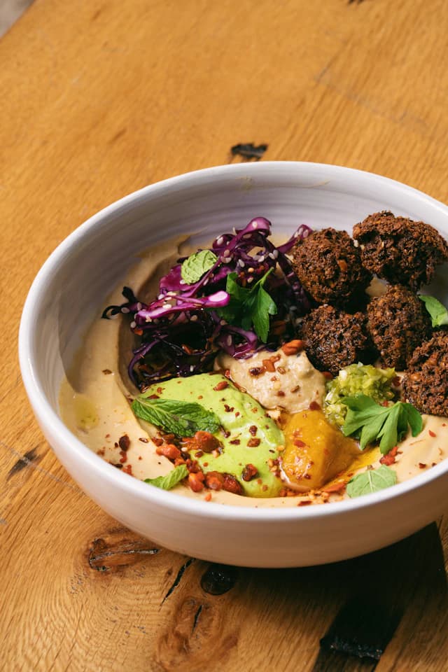 Falafel bowl with grains, greens and purple vegetables — illustrative stock photograph