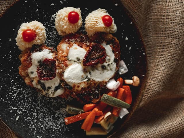 Breaded chicken with melted cheese and tomato sauce — illustrative stock photograph