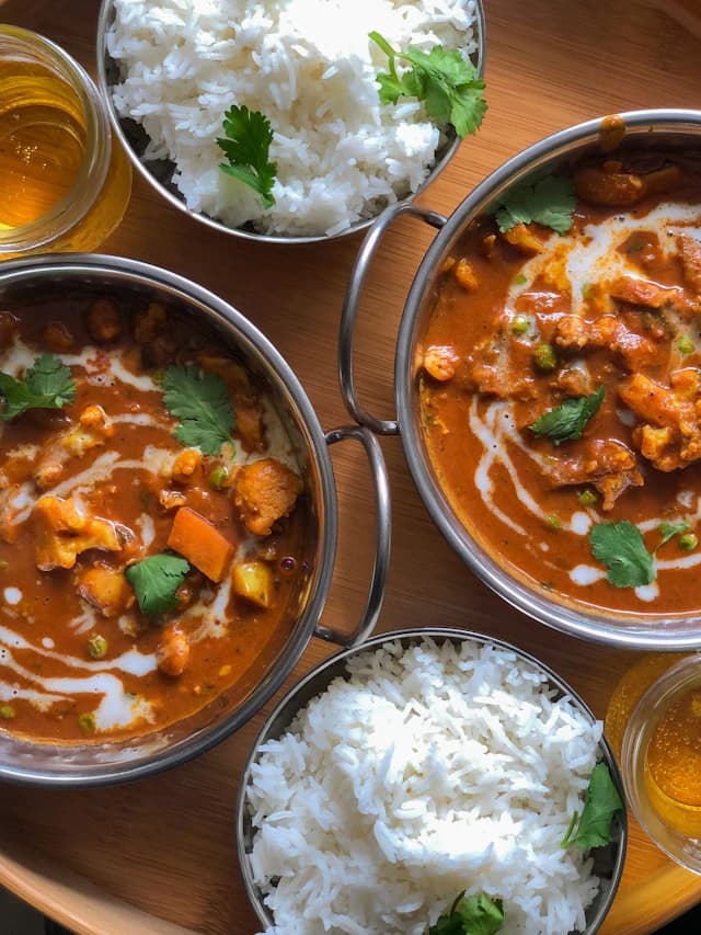 Rich vegetable curry served with rice and accompaniments — illustrative stock photograph