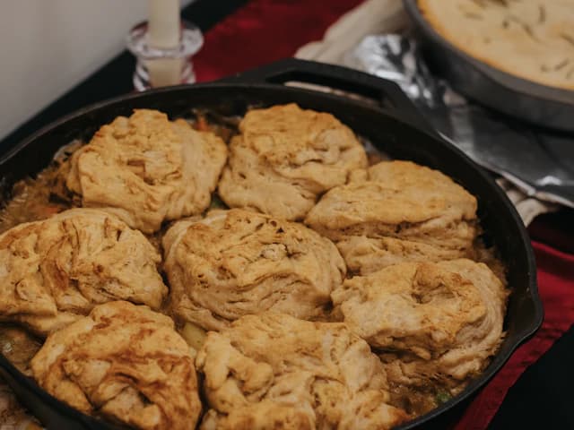 Golden sourdough-crust savoury pie in a cast-iron skillet — illustrative stock photograph