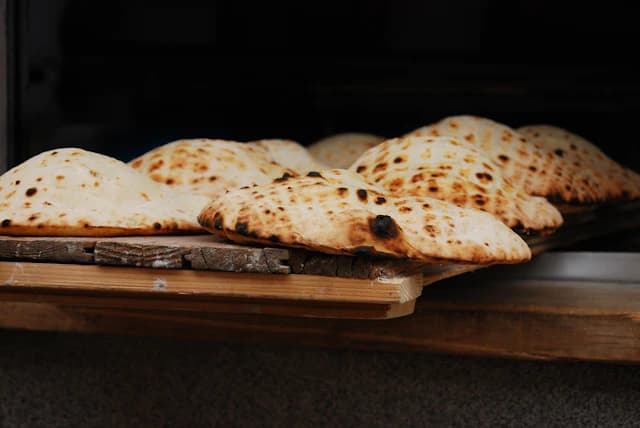 Golden toasted flatbread on a dark background — illustrative stock photograph