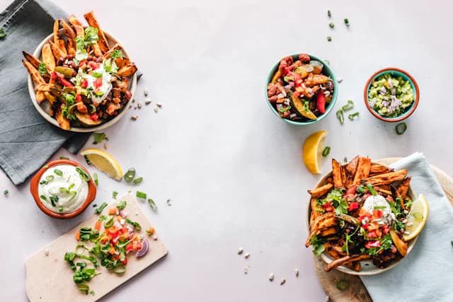 Sweet potato fries bowls with colourful vegetable toppings — illustrative stock photograph