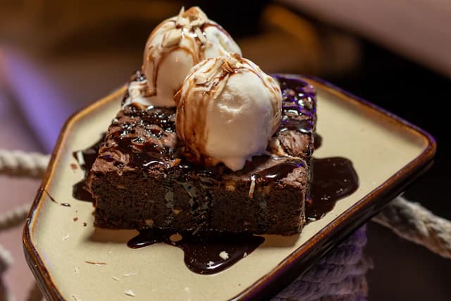 Chocolate brownie served with a scoop of ice cream — illustrative stock photograph