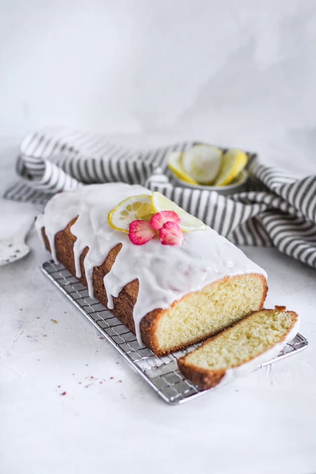 Glazed lemon loaf cake with fresh lemon slices — illustrative stock photograph