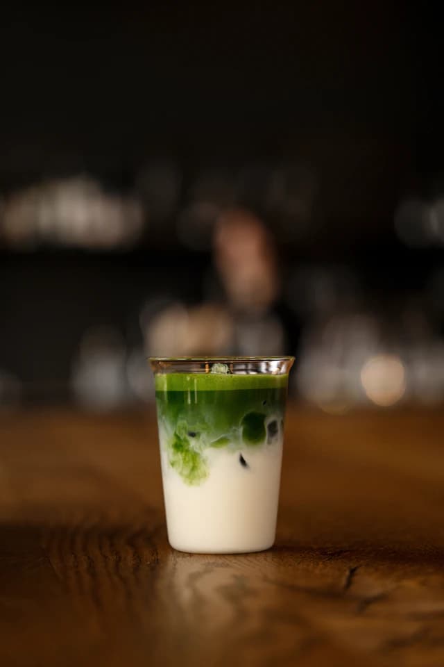 Layered green matcha latte in a tall glass — illustrative stock photograph