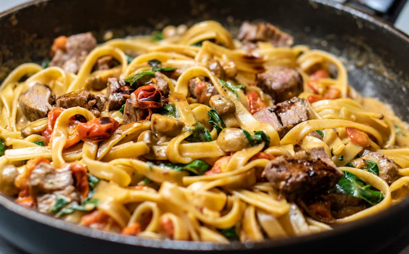 Illustrative pasta dish with tomatoes and herbs