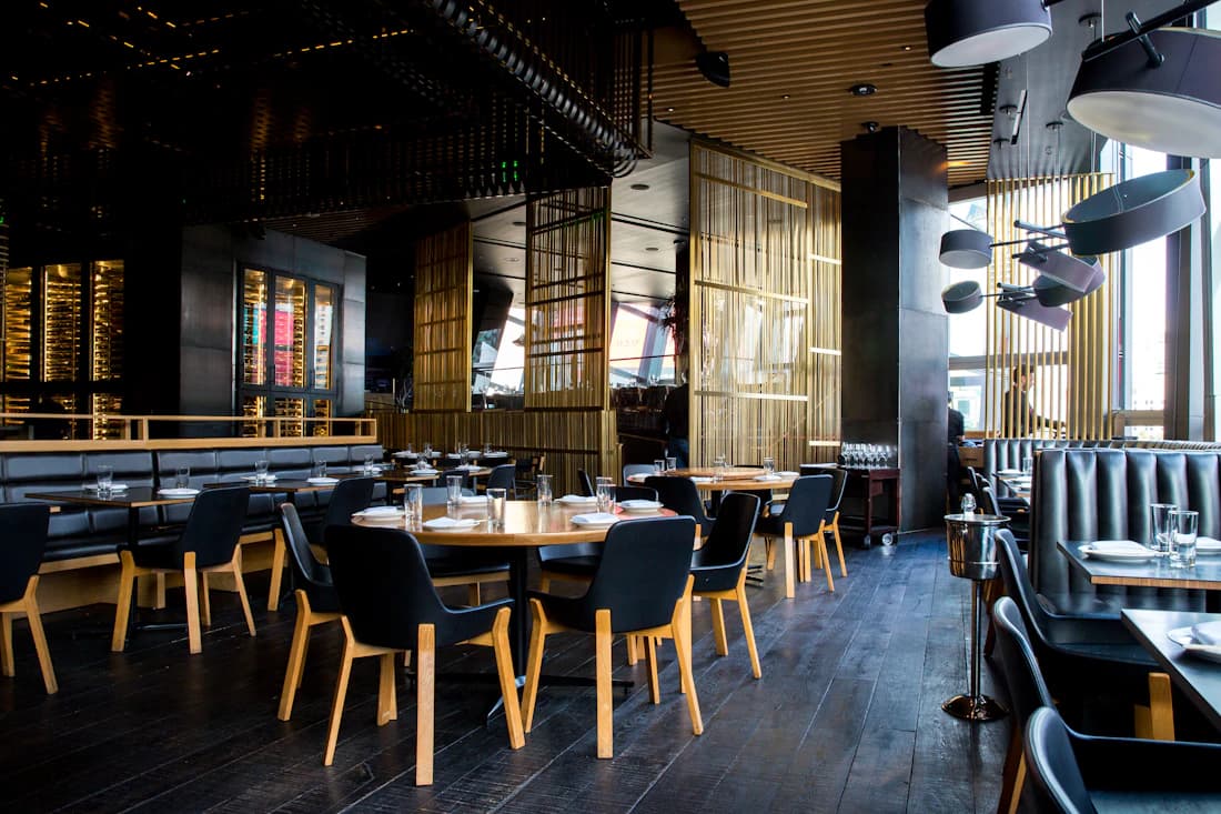 Warm restaurant space with tables and pendant lights